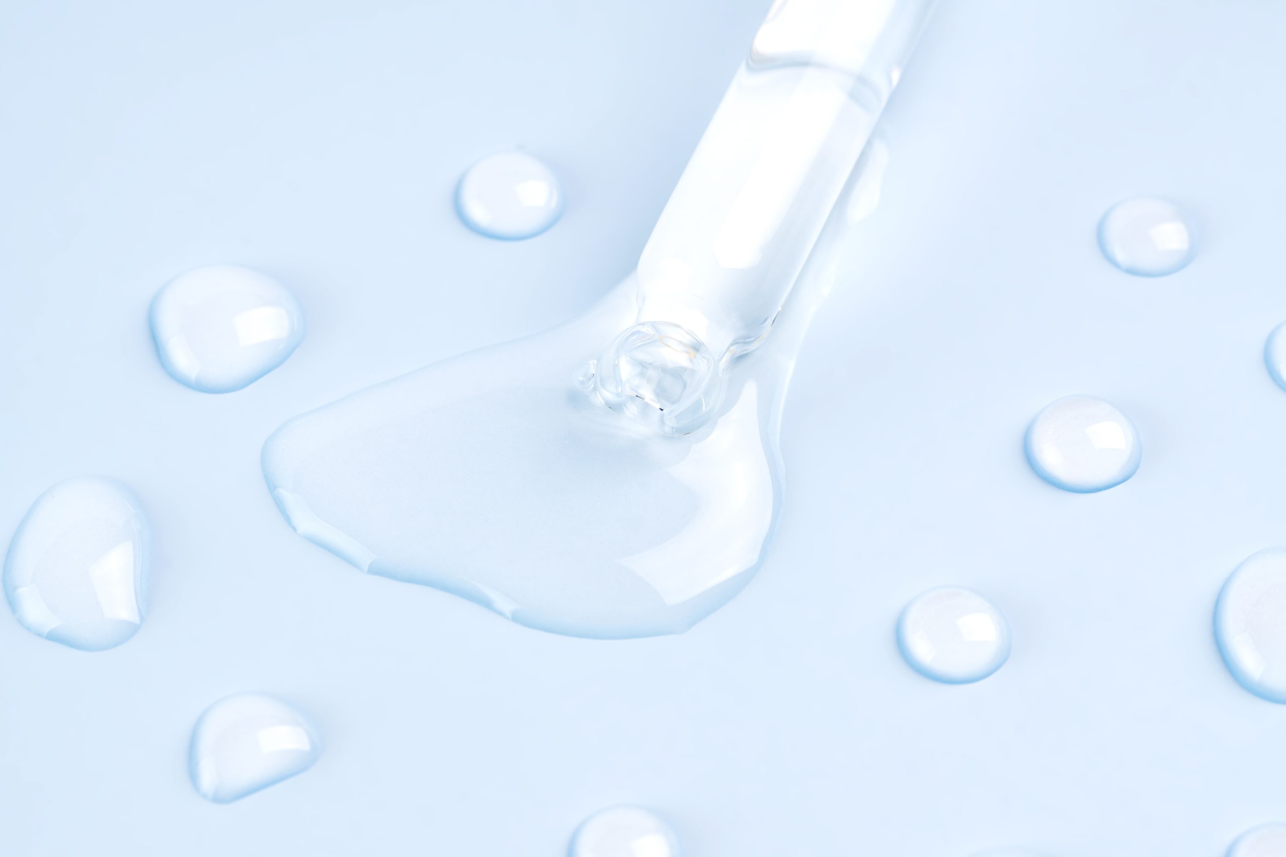 Bottle pipette dropper close up and Liquid hyaluronic serum on a blue background